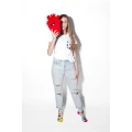 Kobieta w kolorowych skarpetkach mixTURY Organsy trzyma pluszowe czerwone serce przed twarzą, stojąc na białym tle.