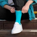 Mężczyzna zakłada morskie skarpetki do białych sneakersów, streetwearowy styl