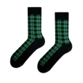 Para eleganckich skarpetek w ciemnej tonacji, ozdobionych klasycznym wzorem zielono-czarnej szkockiej kraty.