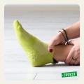 Zbliżenie na stopę w zielonej sportowej skarpetce z systemem antypoślizgowym ABS i oddychającą siateczką, idealna do ćwiczeń fitness, pilatesu, jogi i treningu domowego.