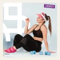 Uśmiechnięta kobieta po treningu siedzi na macie w różowych skarpetkach antypoślizgowych z oddychającą siateczką i spodem ABS, obok leżą hantle – fitnessowa sesja w stylu retro.