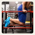 Mężczyzna ćwiczący na czerwonych poręczach w siłowni, ubrany w niebieskie spodenki i morskie skarpetki sportowe z siateczką i powłoką antypoślizgową ABS na spodzie.