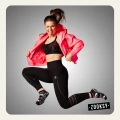 Kobieta w stroju sportowym w dynamicznym podskoku, ubrana w czarne legginsy i czarne skarpetki sportowe z białym antypoślizgowym wzorem i kolorowymi akcentami – idealne do fitnessu, jogi i aktywności na sali.
