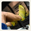 Stopa w żółtej skarpetce sportowej z ABS oparta o metalową platformę na siłowni podczas ćwiczeń