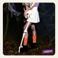 Modelka w halloweenowej stylizacji pozuje w lesie, trzymając szkielet i mając na sobie pomarańczowe skarpetki mixTURY z motywem oczu potworów.