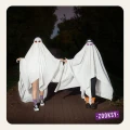 Dwie osoby przebrane za duchy trzymają się za ręce, mając na stopach kolorowe skarpetki mixTURY Halloween. Fioletowe w czaszki i pomarańczowe w oczy potworów.