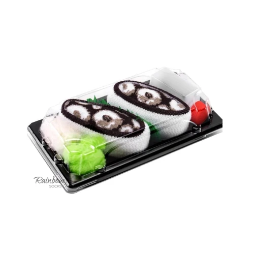 Para skarpet ułożonych w czarnej tackce stylizowanej na sushi, z brązowo-białym wzorem przypominającym kawałki ryby, przykryta przezroczystą pokrywką.